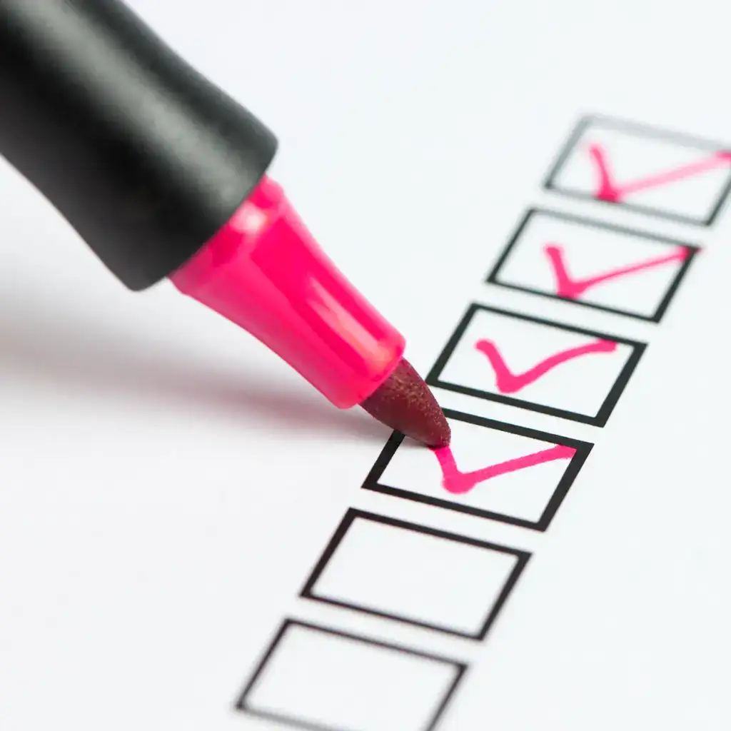 A pink marker pen ticking boxes on a checklist.