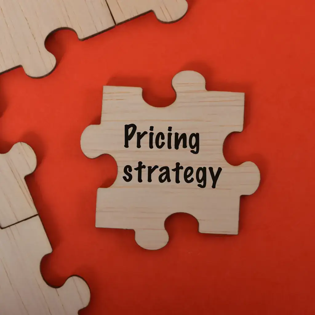 A wooden jigsaw piece with 'Pricing strategy' written on it.